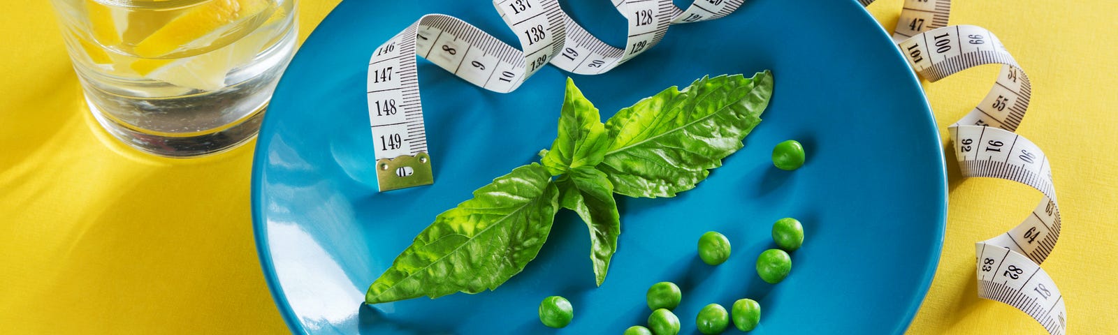 Plate with a fork and tape measure showing just a basil leaf and 12 peas.