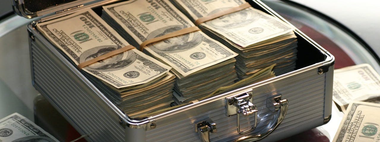 A small silver suitcase full of stacks of money.