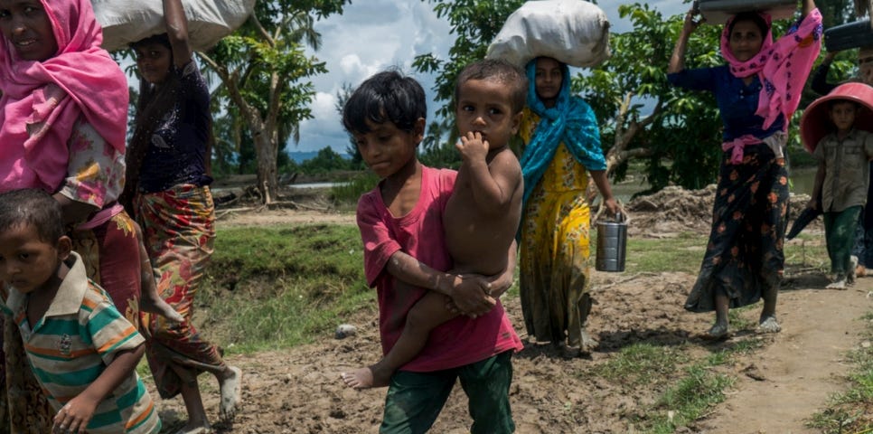 Petit garçon rohingya porte son petit frère pour traverser la frontière