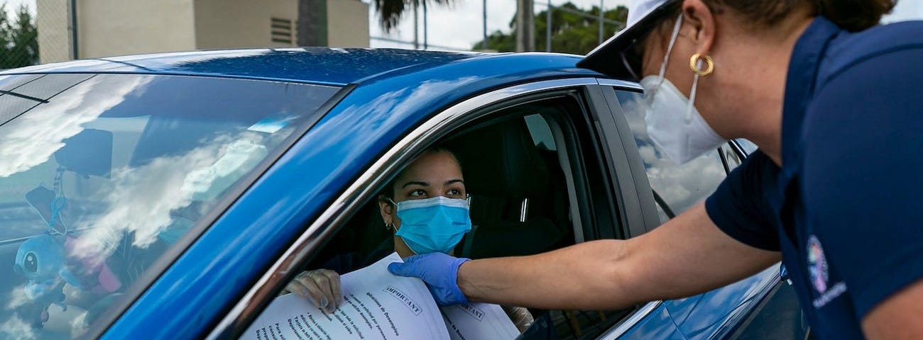 Tatiana Fernández distributes unemployment documents to residents of Miami-Dade County in Hialeah, Florida, on April 7.