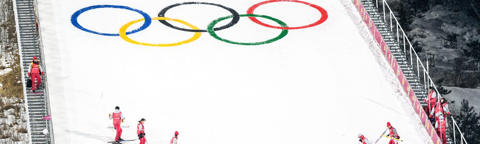 A team standing on the Olympic logo.