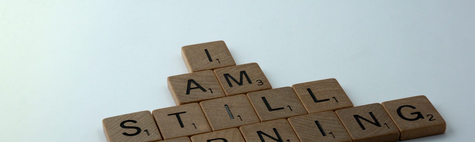 Scrabble tiles spelling out ‘I AM STILL LEARNING’.