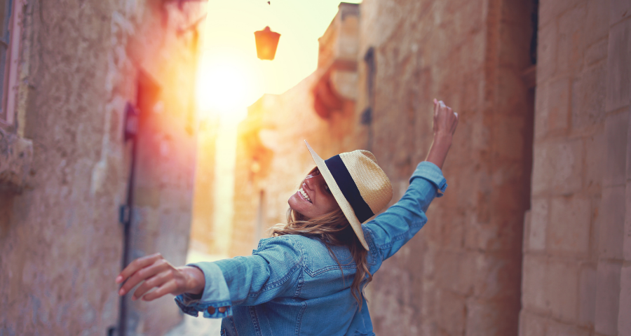 Image of happy woman joyfully walking through the streets