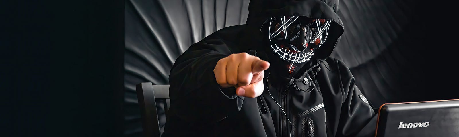 IMAGE: A person in a hoodie in black and white pointing at the camera with a hand in color.