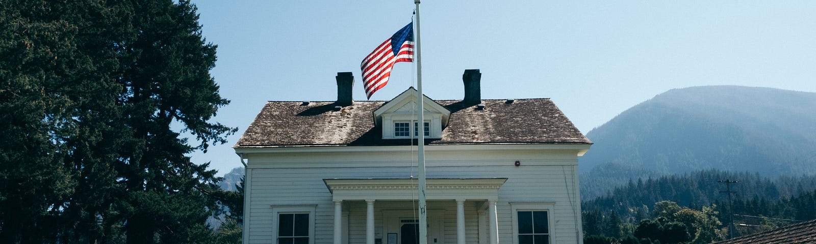 Small white house with American flag in front