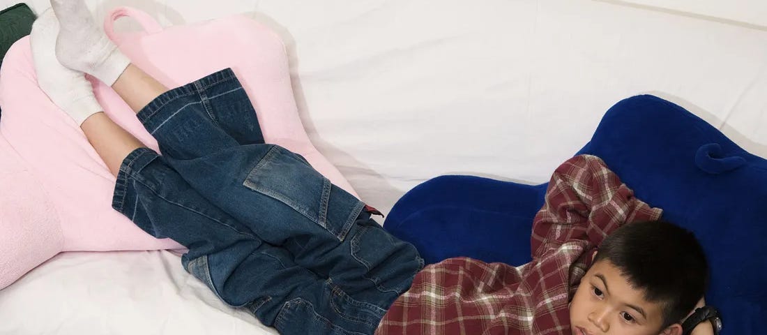Kid lying on a couch, looking bored.