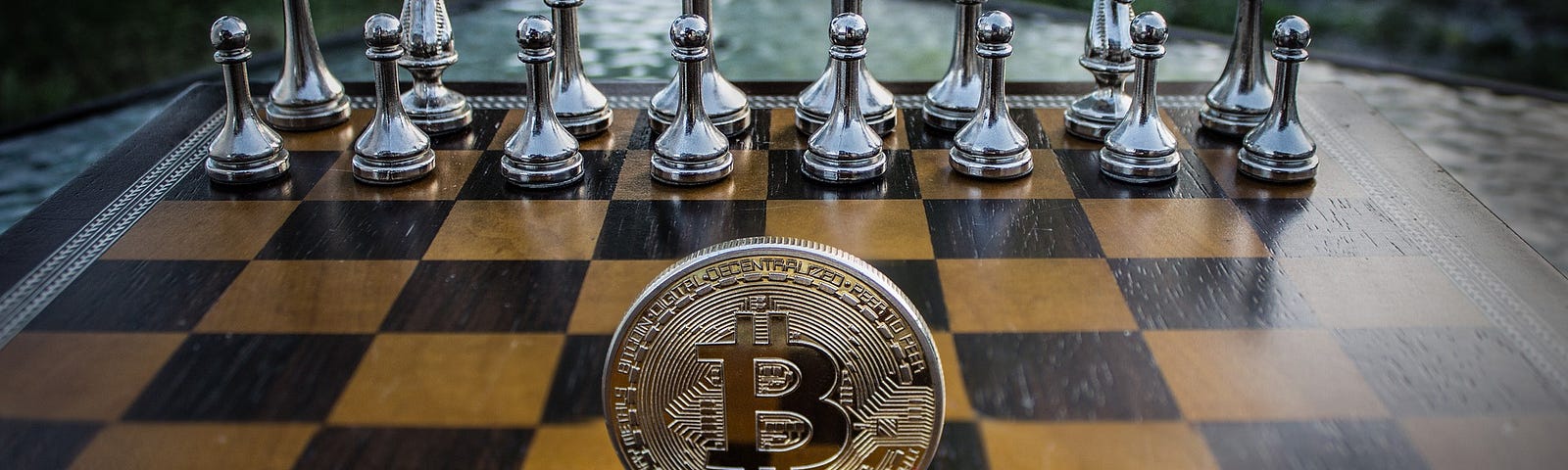 A metal coin with the Bitcoin logo standing on its edge in the middle of a chess board