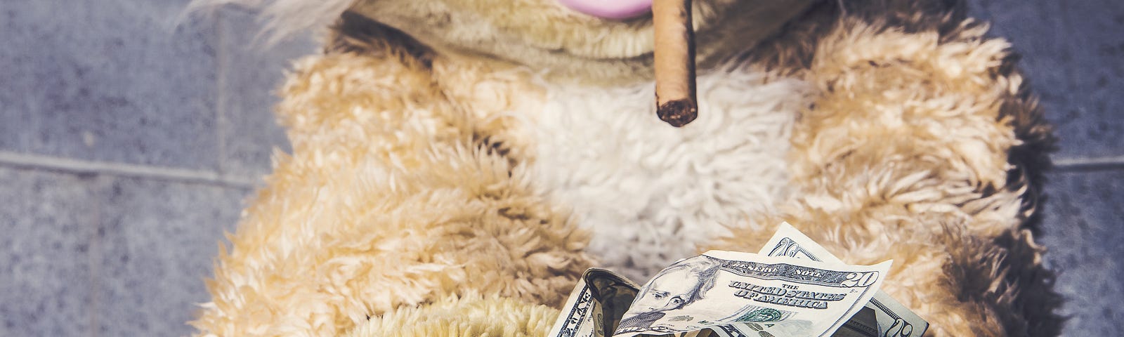 A stuffed rabbit with a Cheshire smile and a cigar in its mouth, grinning at a pile of money.