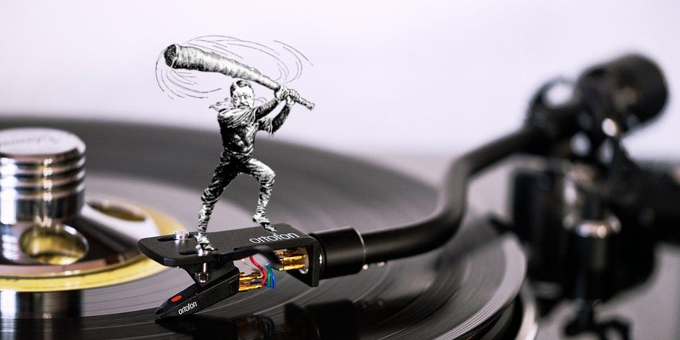 A turntable with a caricature of Teddy Roosevelt as a trustbuster, standing on the tonearm, wielding his ‘big stick.’