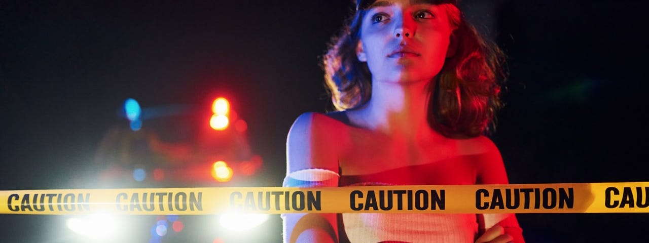 young girl with curly hair and in hat standing outdoors near police line tape conception of crime or riot
