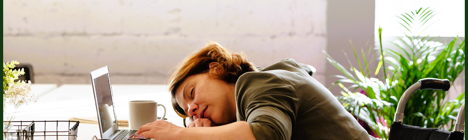 A woman slumped over her desk exhausted