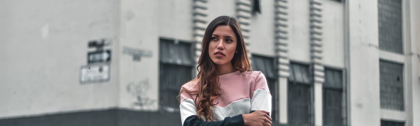 woman standing beside gray and white building