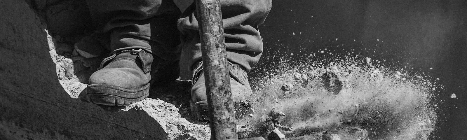 Black and white, sledge hammer breaking concrete