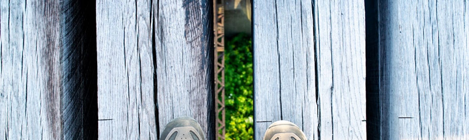 You are standing on a high bridge over a canyon made out of wooden planks. You look down at your feet in hiking boots and your feet are hip width apart but the gap between the planks is almost as wide as your feet. You see the greenery growing on the canyon floor and you get a weird sense of being pulled down that space between the planks as your legs drift apart. The threat you feel is created by sensory distortion.