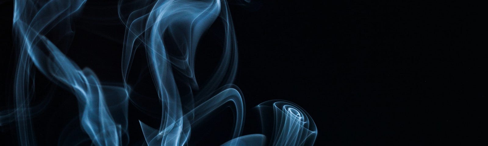 Whisps of smoke against a black background