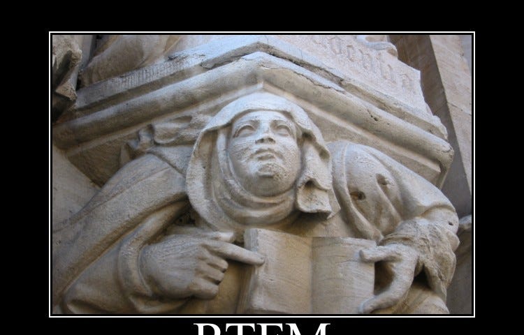 A sculpture on on a building showing a person holding a book and pointing to it with their index finger. The caption underneath reads “RTFM before you ask!”.