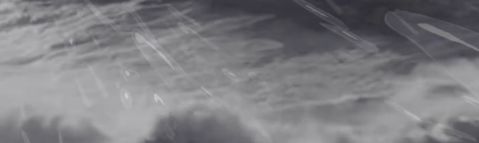 A black and white video still of waves and crests, with illustrated streaks of water droplets superimposed over it.