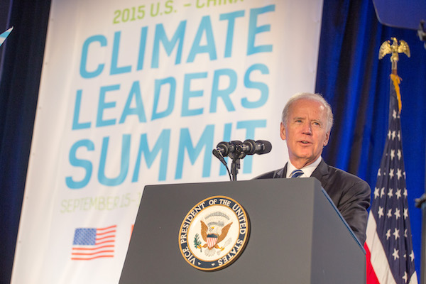 President Biden stands in front of a podium with a sign reading “Climate leaders summit behind him.”
