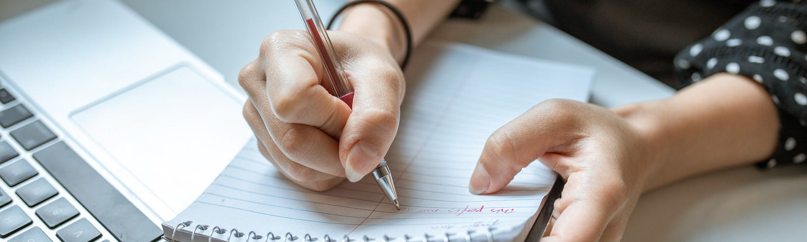 A person writing on a notebook.