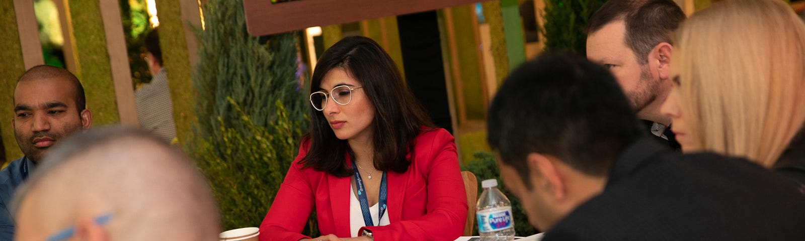 Woman in red blazer consults with other Salesforce partners.