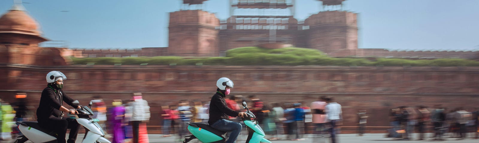 Two electric scooters with Delhi’s Red Fort in the background