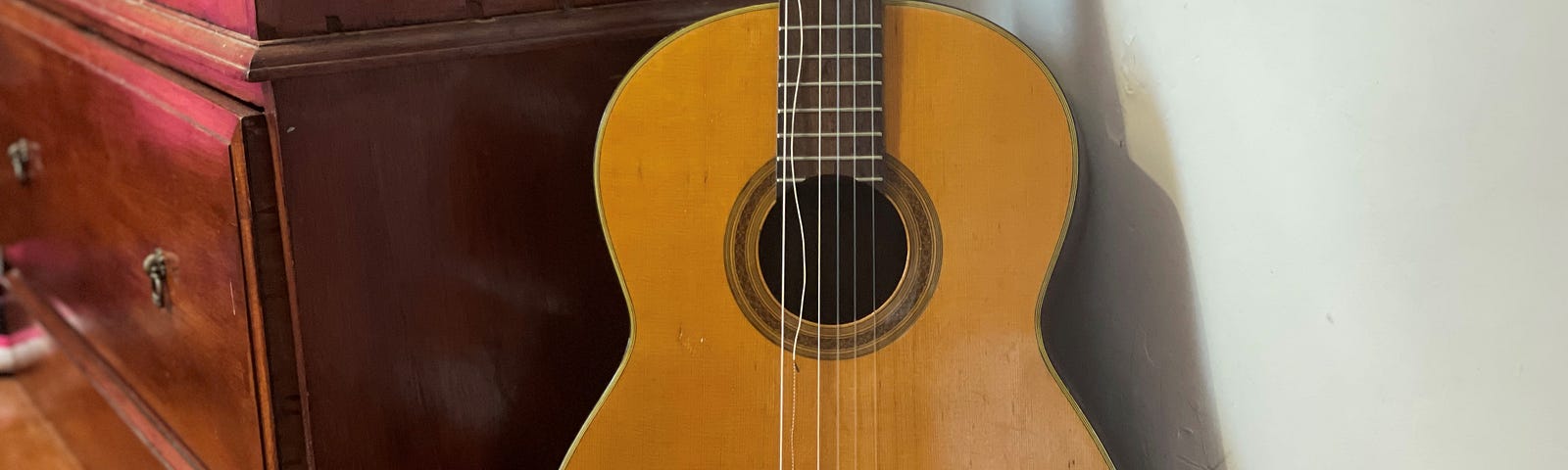 An old acoustic guitar with broken strings.