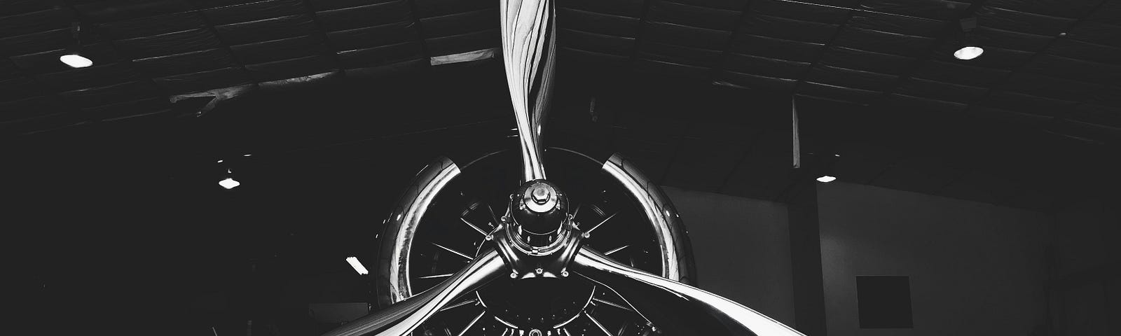 A black and white photo of the front of an airplane propeller.