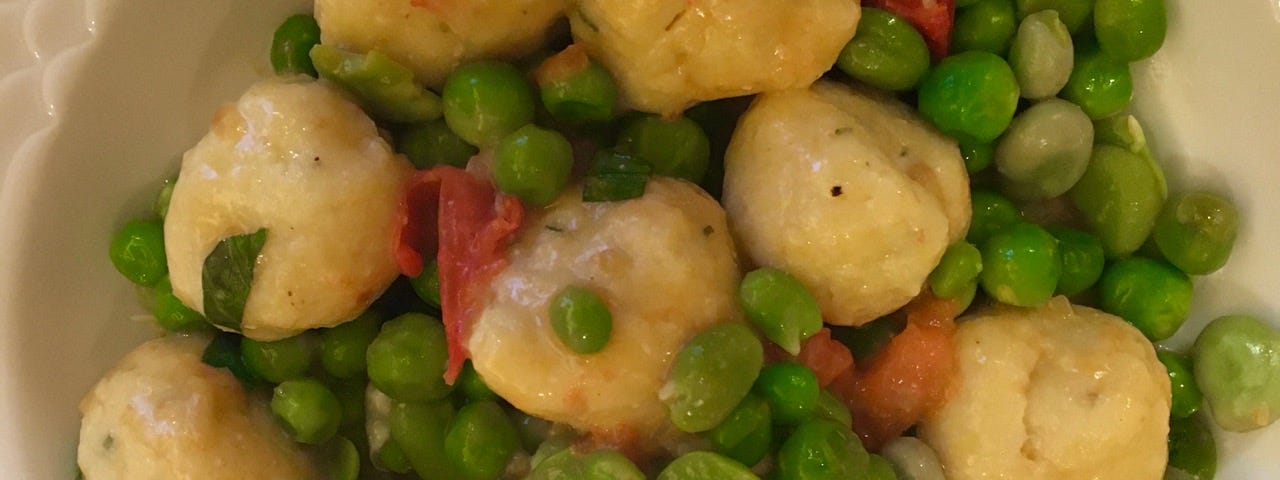 The peas and dumplings on a dinner plate.