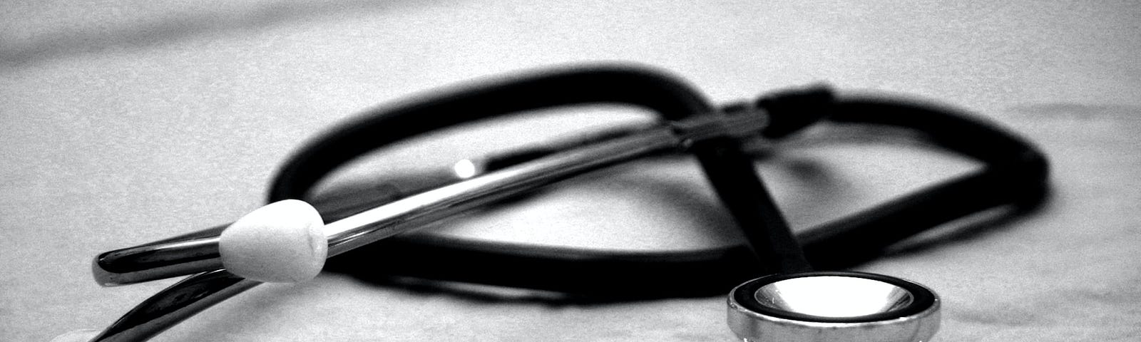 A tangled stethoscope sitting on top of a sheet