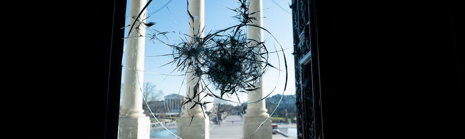 The east front of the U.S. Capitol seen through a shattered door on January 7, 2021, the day after the riot. Photo by Bill Clark/CQ Roll Call via AP Images