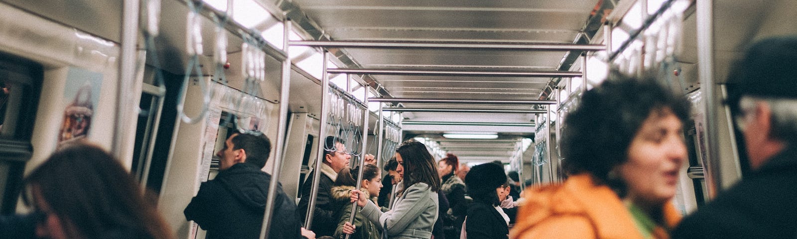 A full metro car full of people commuting on a work day