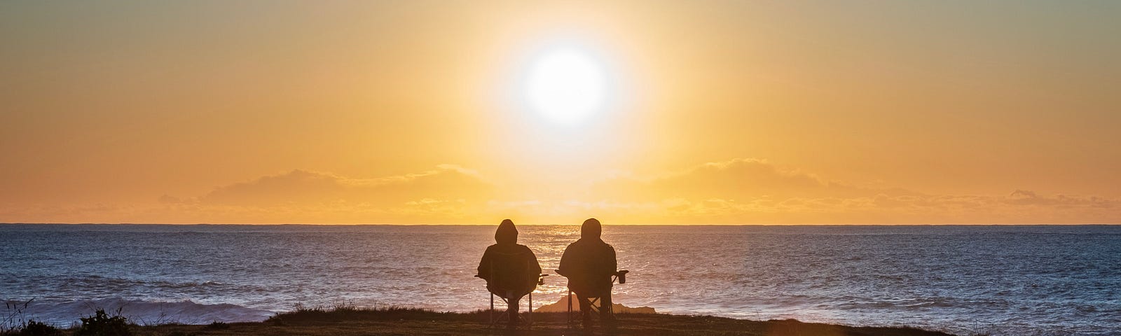 People sitting on the beach at sunset