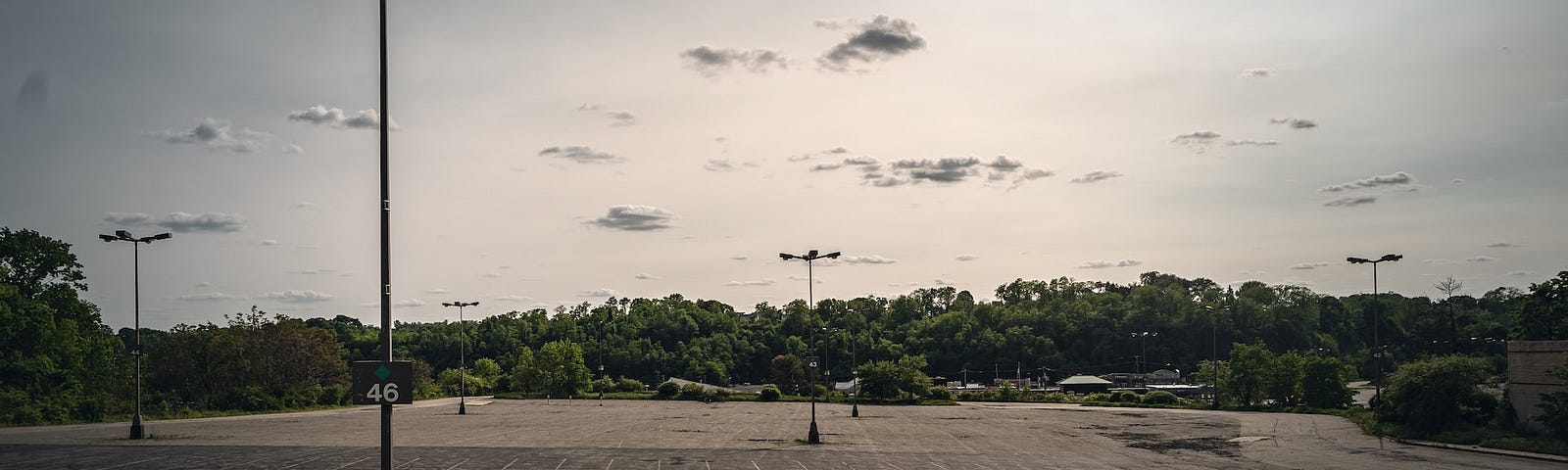 Empty parking lot surrounded by trees.