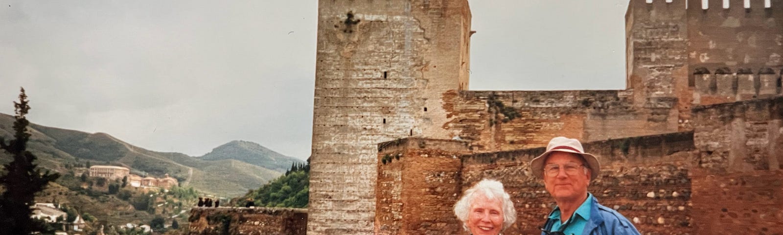 A photo taken of Charme and Warner Hughes in front of an old castle.