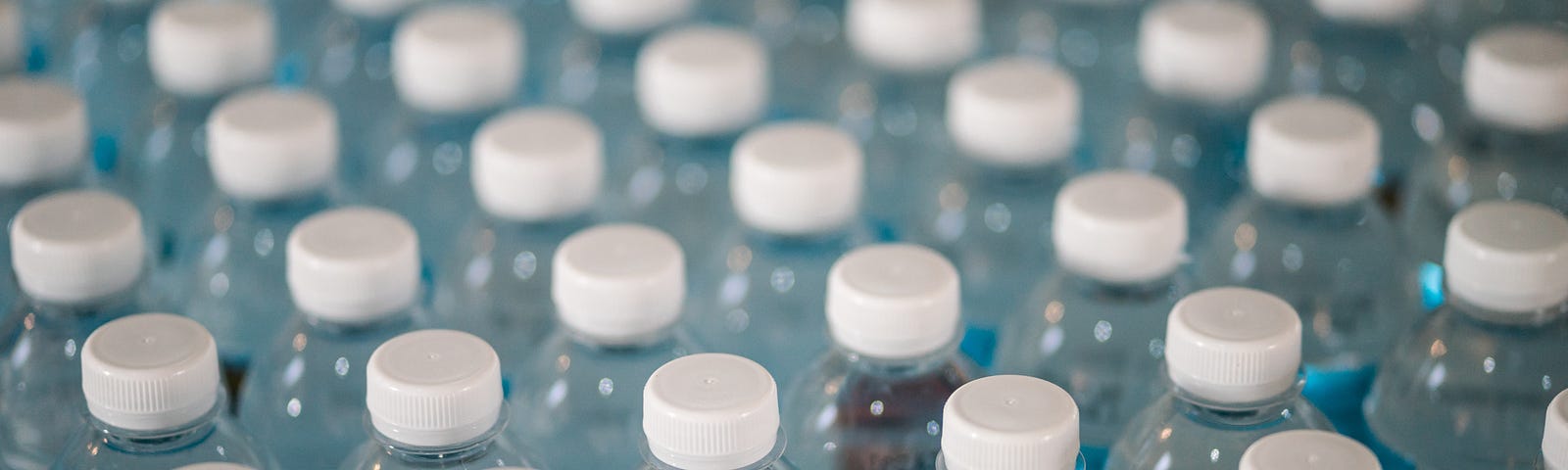 Close up of dozens of bottles of water, as seen from above.