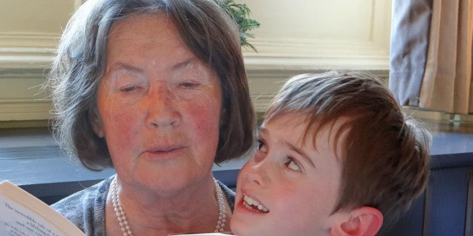 A grandmother is reading a story to her grandson.