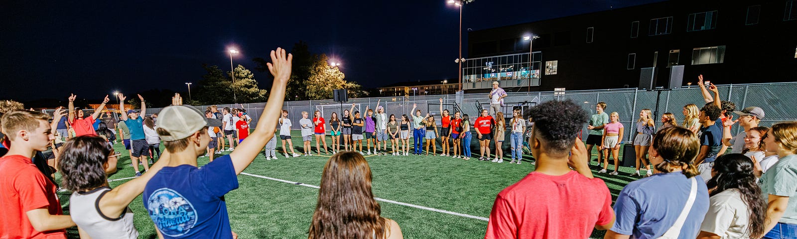 Students raise their hands during an ice breaker game at the Playfair