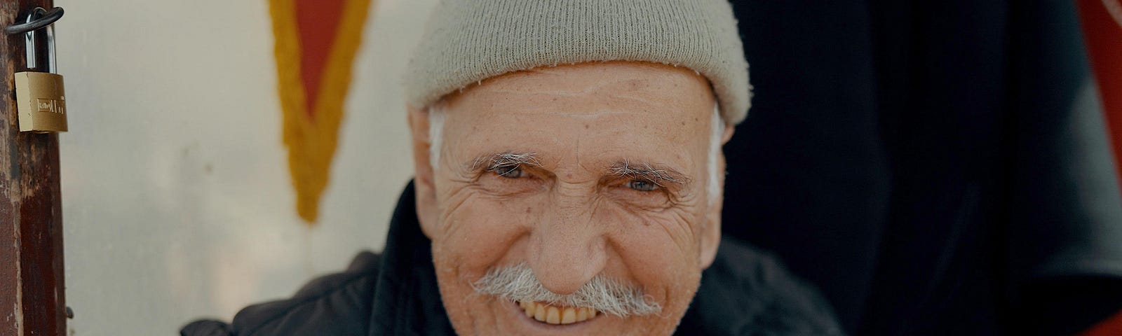 A man with a mustache smiles for the camera