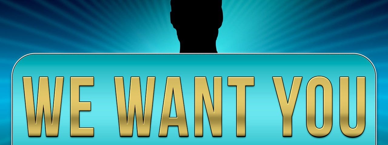 Image of a man in shadow holding a sign saying ‘We want you’ — context is a job offer situation