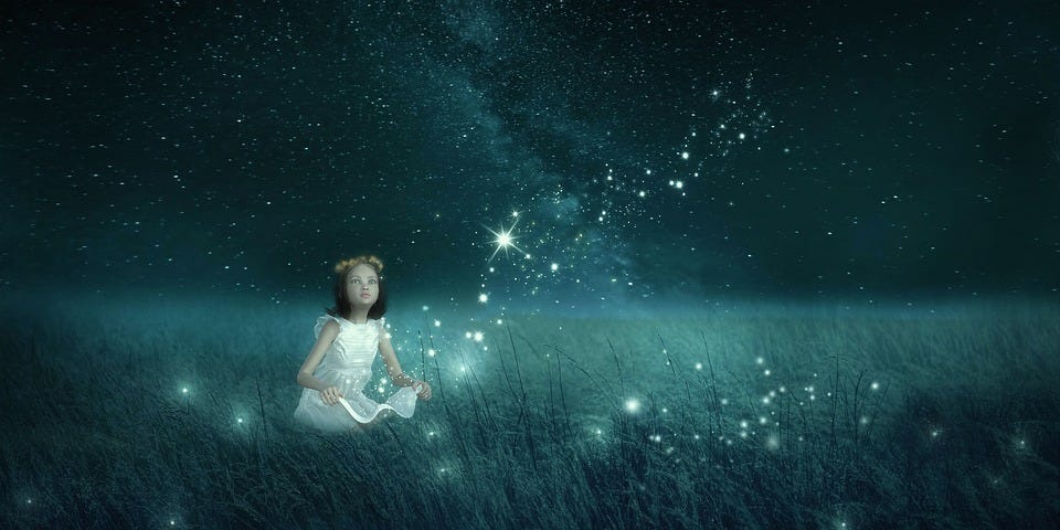 A girl sits in a field surrounded by fireflies.