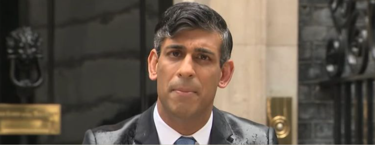 Rishi Sunak, the Prime Minsiter of the UK standing in the rain outsode Number 10, announcing the election.