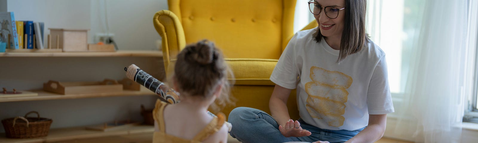 A mom plays instruments with her daughter in a living room.