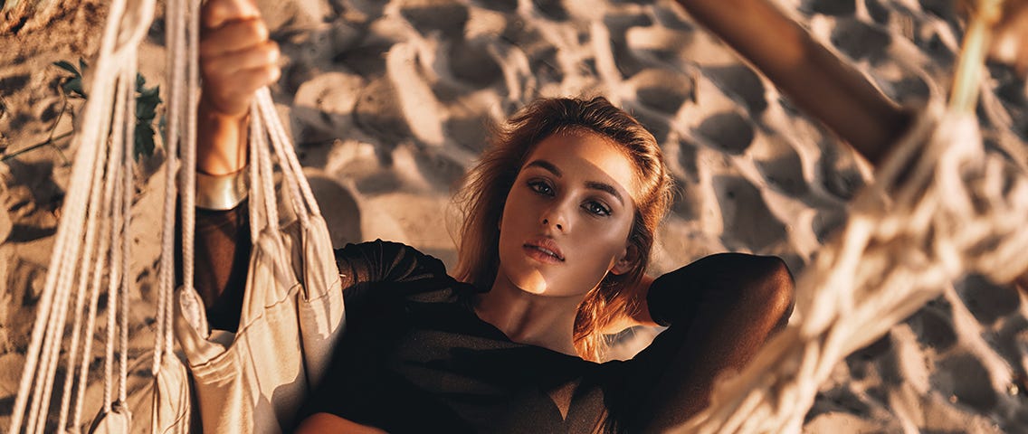 just-relaxing-top-view-attractive-young-woman-looking-camera-while-lying-down-hammock-beach — Un Swede