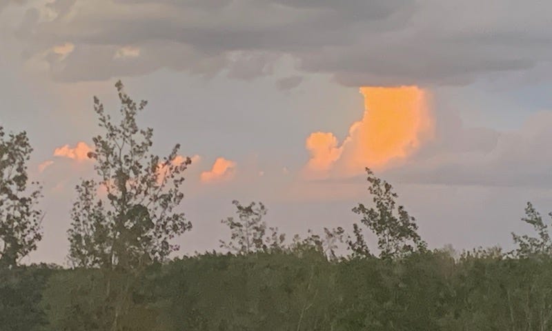 The gray sky with the sun reflecting off a cloud