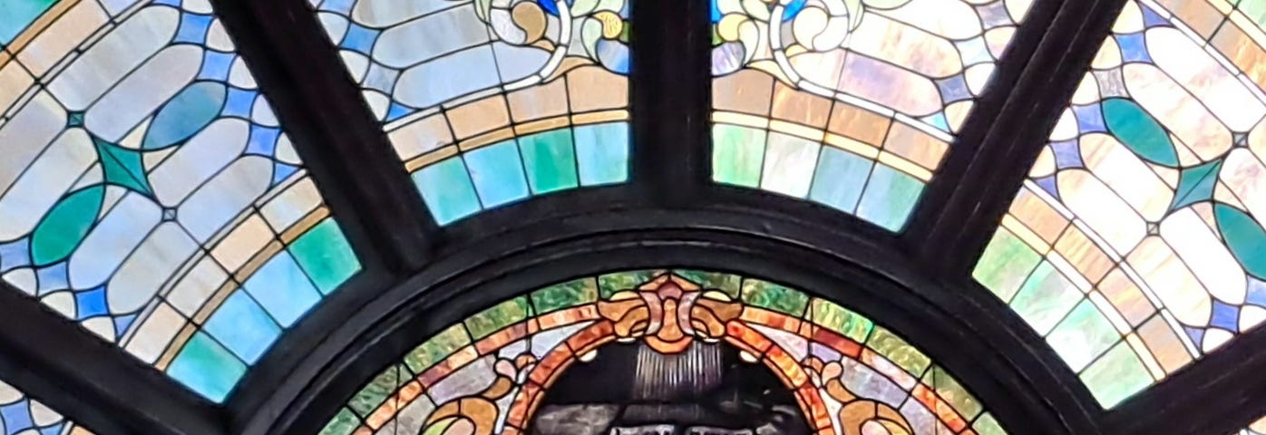 Stained glass church window with open bible in center