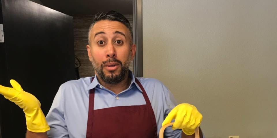 Me wearing an apron and rubber gloves holding a tea kettle used in the investment process.