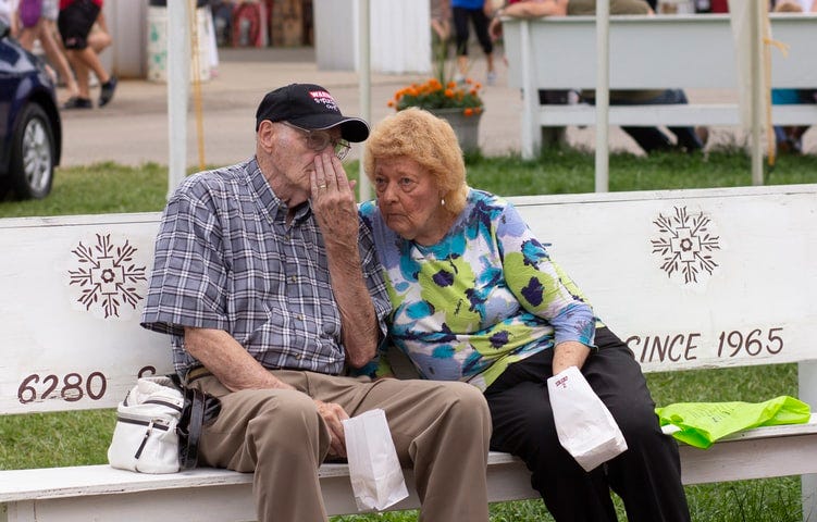 An image of an elderly couple sitting on a bench.