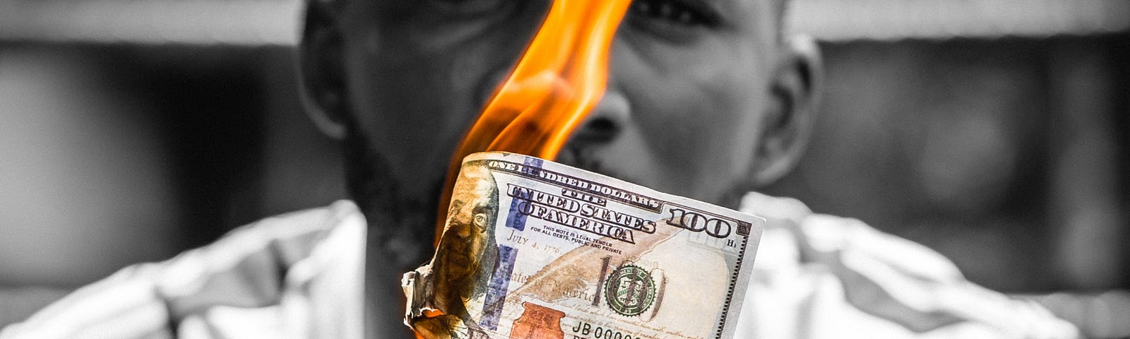 Man holding burning cash money