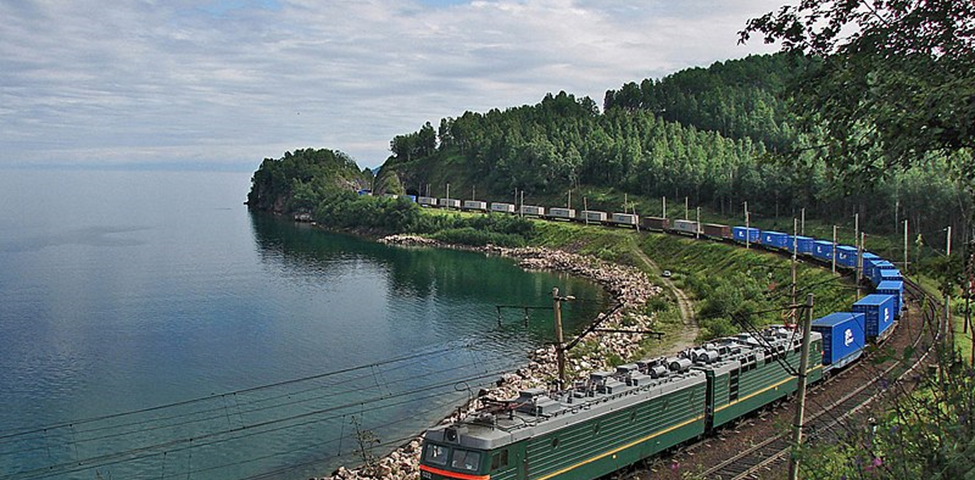 File: VL 85–022 container train.jpg English: BoBoBo+BoBoBo VL85 class AC electric locomotive VL85–022 with a container train on the coast of Lake Baikal, Trans-Siberian Railway: the stretch between Utulik-Slyudyanka. Author Sorovas This file is licensed under the Creative Commons Attribution-Share Alike 3.0 Unported license. https://creativecommons.org/licenses/by-sa/3.0/deed.en https://commons.wikimedia.org/wiki/File:VL_85-022_container_train.jpg