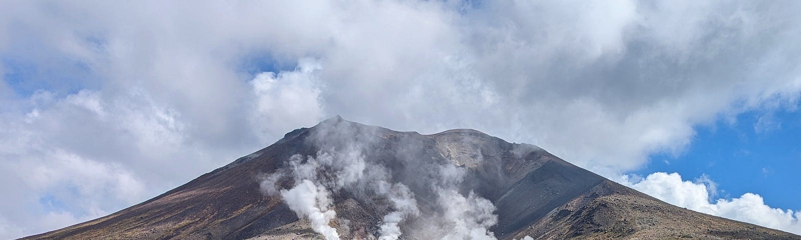 Mountain with fumaroles rising like steam vents